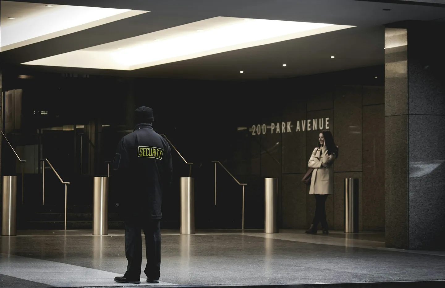 Security guard standing in a corporate building lobby at night